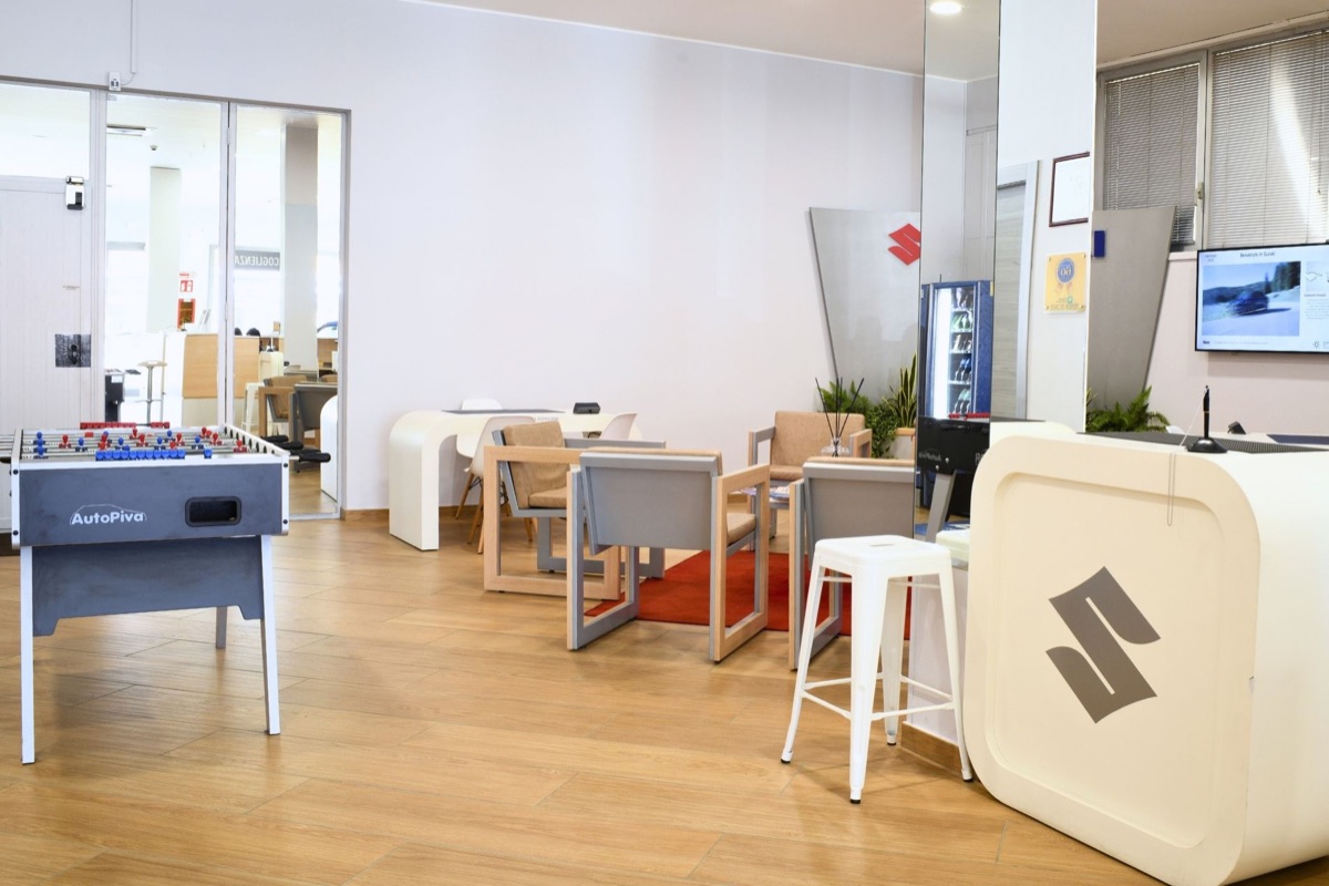 Sala d'attesa dello showroom AutoPiva con biliardino e area ospiti