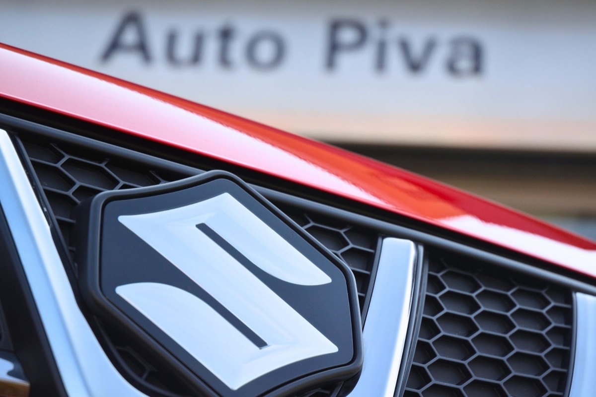 Dettaglio del logo Suzuki su una Suzuki rossa davanti alla concessionaria AutoPiva